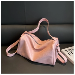 Detailed macro of pink pebbled leather handbag with adjustable strap and silver hardware