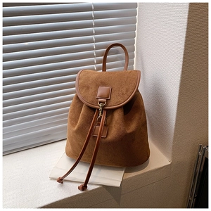 Close-up of brown suede backpack showing premium matte texture and retro metal hook detail