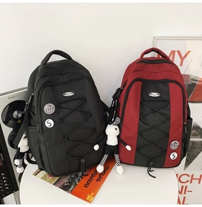 Détail de sacs à dos en nylon noir et rouge avec cordons élastiques et pendentif lapin