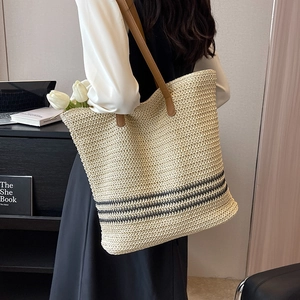 Large woven straw tote bag with black stripes and brown leather straps for summer beach use