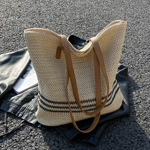Large beige woven straw tote bag with black stripes and brown PU shoulder straps