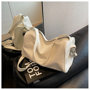 Detail of white embossed leather boston bag with premium texture and silver zipper