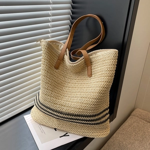 Large woven straw tote bag with black stripes and brown leather straps for summer beach