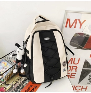 Détail du sac à dos en nylon avec cordons, badges et porte-clés chien à damier