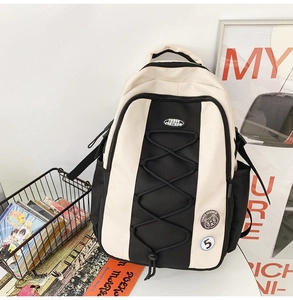 Détail du sac à dos en nylon de style collège avec cordon et badges décoratifs
