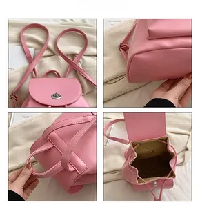 Detail view of pink PU leather backpack showing metal turn-lock, stitching and inner lining