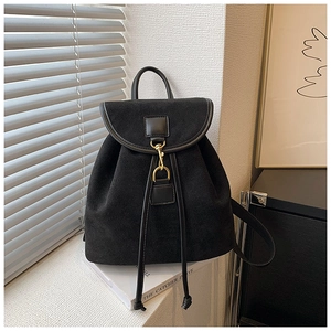 Close-up of black matte backpack with elegant gold hook clasp and drawstring detail