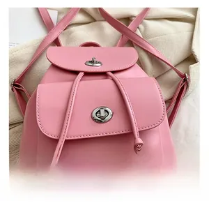 Detailed close-up of pink leather backpack with silver dual metal twist locks and drawstring