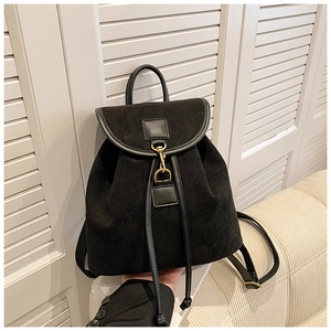 Detail of black suede backpack featuring leather trim and gold metal hook closure