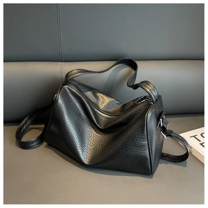 Close-up of black crocodile pattern faux leather texture and silver zipper on Boston bag