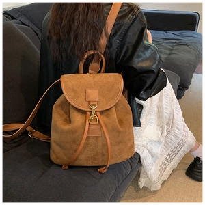 Close-up of vintage brown suede backpack with metal hook and leather drawstring detail