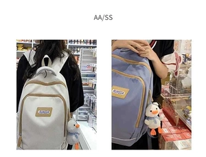 Detail view of the multi-layer zipper compartments and duck pendant on canvas backpack