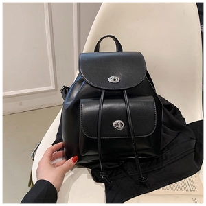 Détail d'un sac à dos noir en cuir avec fermoirs rotatifs argentés et cordon de serrage