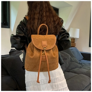 Brown frosted retro backpack with drawstring closure and metal hook on model's back