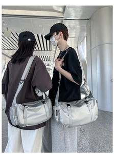 Detail of silver metallic travel bag with side shoe compartment and mini strap pouch