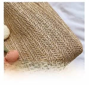 Close-up of woven straw tote bag with pink floral accents and texture detail