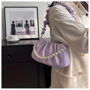 Detail of lavender pleated cloud bag featuring pearl chain and fabric shoulder strap