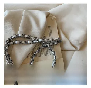 Détail de la bandoulière chaîne argentée avec cuir sur un sac à main blanc chic