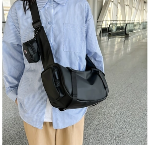 Detail of black multi-compartment travel bag with adjustable strap and mini coin pouch