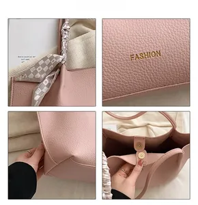 Detail of pink pebbled leather tote with FASHION gold stamp and silk scarf handle