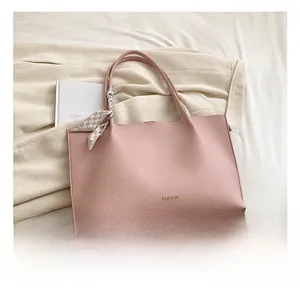 Detail of pink lychee leather tote bag with fashion text and checkerboard scarf