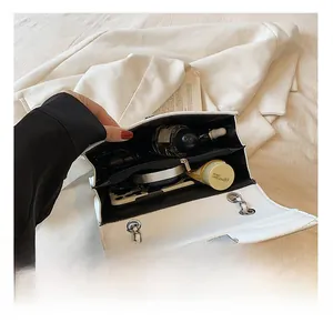 Vue intérieure du sac blanc matelassé montrant trois compartiments et sa capacité