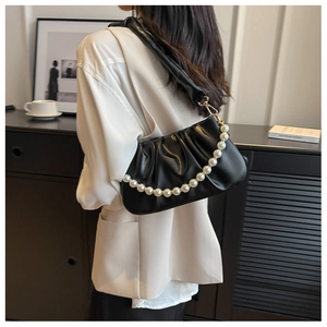 Detail shot of black ruched cloud bag with premium pearl chain and leather shoulder strap