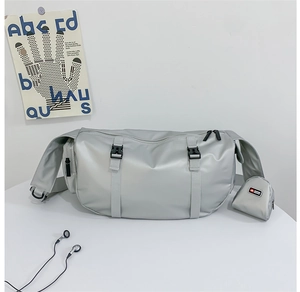 Detail of silver-grey large crossbody travel bag with buckled straps and round coin pouch