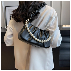 Close-up of black ruched cloud bag featuring large pearl chain and gold hardware