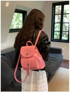 Vue arrière d'un mini sac à dos rose en similicuir avec fermoir rotatif et cordon serrage