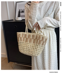 Detail of hand-woven straw beach bag with contrast beige and brown pattern and handles