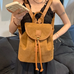 Minimalist brown suede backpack with gold hardware and flap closure for women