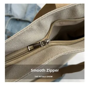 Close-up of the smooth metal zipper and textured canvas fabric on the tote bag