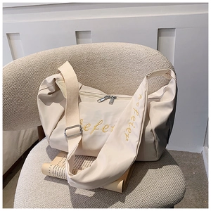 Detail of beige oxford crossbody bag with yellow efeler embroidery and wide strap