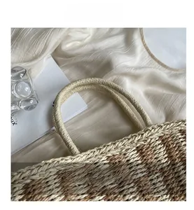 Detailed close-up of woven straw texture and durable handle on a beach tote bag