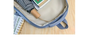 Detailed interior of large capacity light blue backpack showing books and folded umbrella
