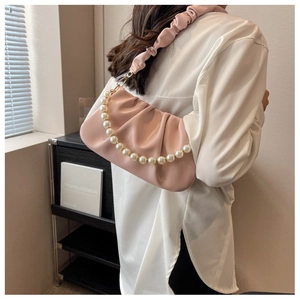 Detail of pink pleated cloud bag with elegant pearl strap and soft PU texture