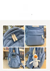 Macro detail of light blue canvas backpack featuring side pocket and duck charm