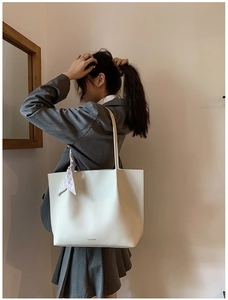 Detail of white tote bag with lychee texture, FASHION embossing and checkered scarf