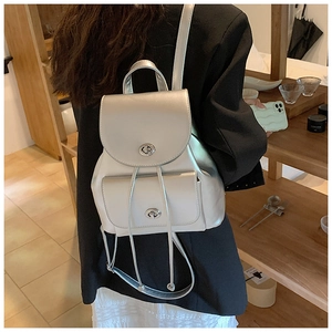 Detail of silver metallic leather backpack with double flip pockets and turn-lock closure