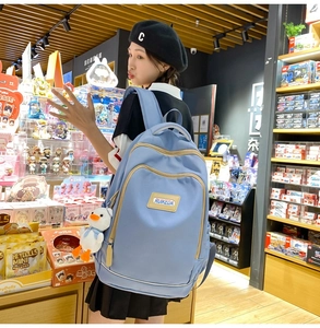 Light blue nylon backpack with white duck charm showing large capacity and zipper details
