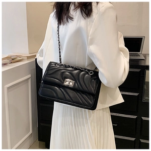 Détail du sac à bandoulière matelassé noir avec chaîne argentée et fermoir en métal