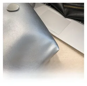 Close-up of silver metallic textured leather and matte silver buckle on bucket bag