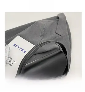 Detail showing the rounded handle and sleek metallic buckle of this black leather saddle bag