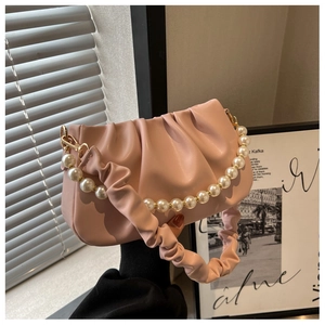 Detail view of pink pleated cloud bag featuring a pearl chain and matte PU leather texture
