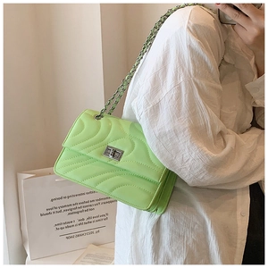 Détail du sac bandoulière matelassé vert fluo avec fermoir rotatif argenté et chaîne