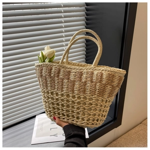 Close-up of dual-tone woven straw bag with hollow mesh texture and rounded handles