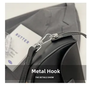 Close-up of durable silver metal hook and black leather shoulder strap of the saddle bag