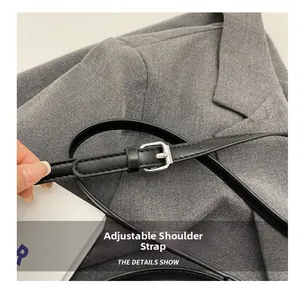 Detail of adjustable black PU leather shoulder strap with silver metal buckle on bag
