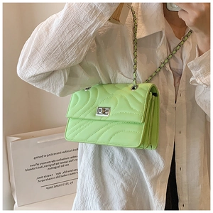 Détail du sac à bandoulière matelassé vert clair avec fermoir rotatif argenté